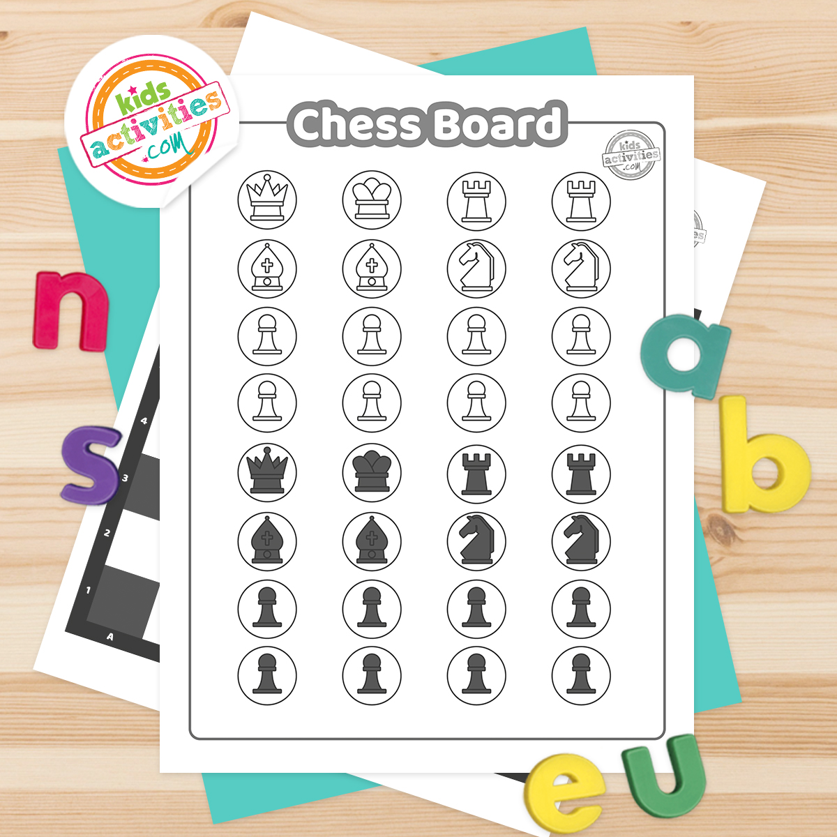 Black & white printable chess set pages on top of a turquoise page laying on a wooden surfaces with colorful letters scattered around.