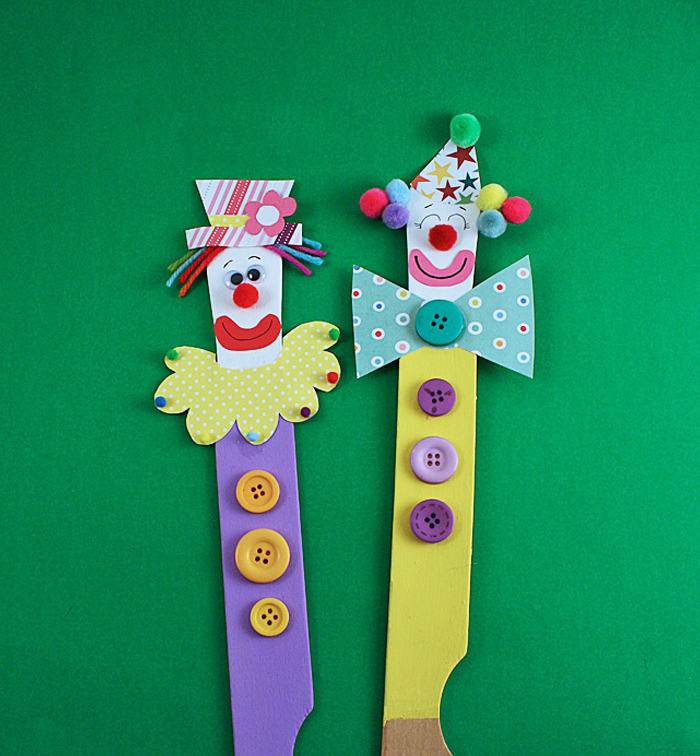 Circus Crafts and Carnival Crafts- Image shows twopaint stick clown puppets over a dark green background. From Kids Activities Blog