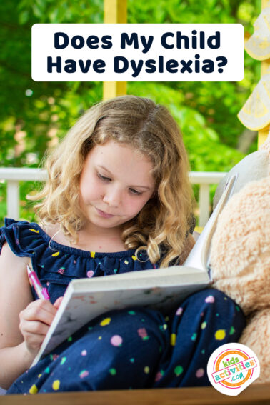 blonde young girl sitting on a porch reading a book