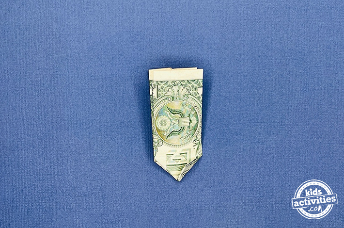 Dollar bill origami pants - Step 5 - Fold the bottom left corner up, then unfold it to create a crease. Use this crease to tuck the corner neatly between both layers of the bill. Repeat with the lower right corner.