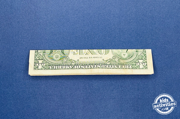 Dollar bill origami pants - Step 1 - fold it in half lengthwise and then crosswise. 