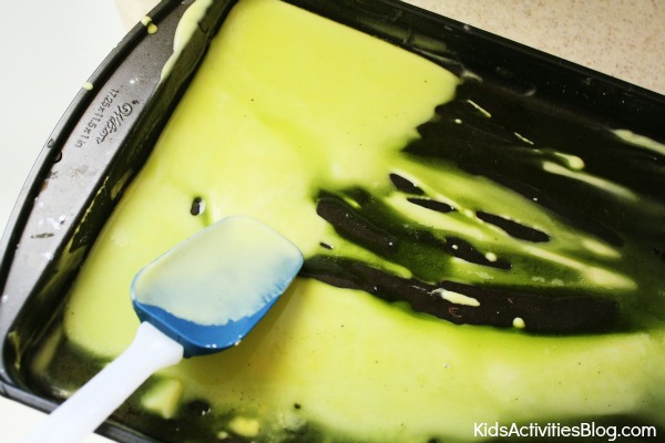 Make Art With Baking Soda And Vinegar - what it looks like when you add more vinegar and stir it with a spatula on the baking sheet - green slimy mess - Kids Activities Blog