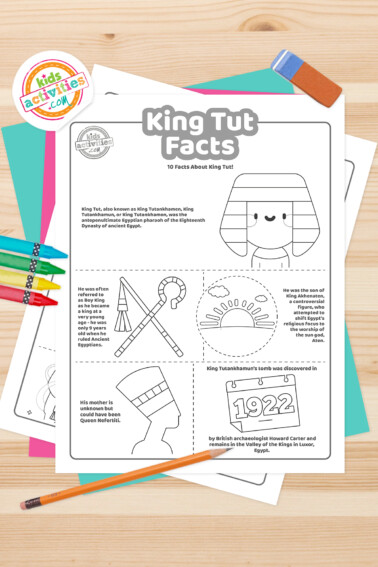 Black and white coloring pages with King Tut facts lying on top of a blue-green sheet with multicolored letters on a light brown background.
