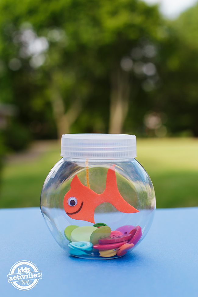Mini Fishbowl Craft- orange fish with a smile and googly eye with a string, jar, and buttons
