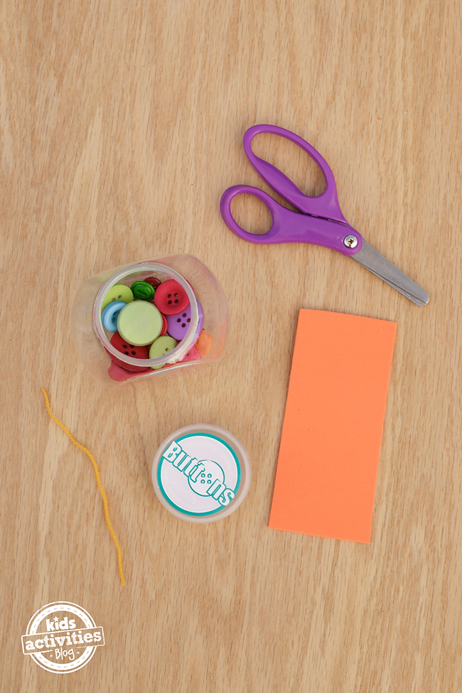 Mini Fishbowl Craft- scissor, jar, buttons, string, lids, and orange paper