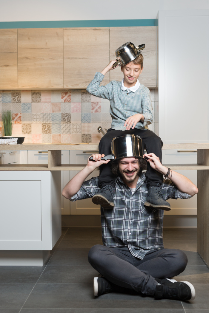 Make new Years eve memories- man and woman sitting in kitchen with pots on their head- kids activities blog