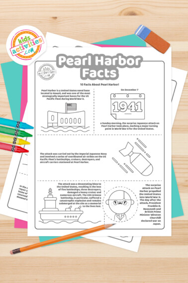 Black and white coloring pages with Pearl Harbor facts lying on top of a blue-green sheet with multicolored crayons on a light brown background.
