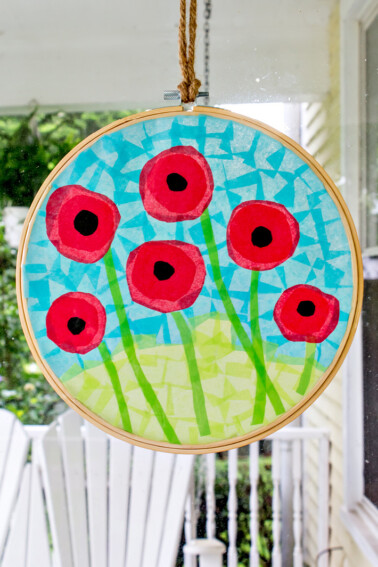 A poppy suncatcher tissue paper craft inside an embroidery hoop