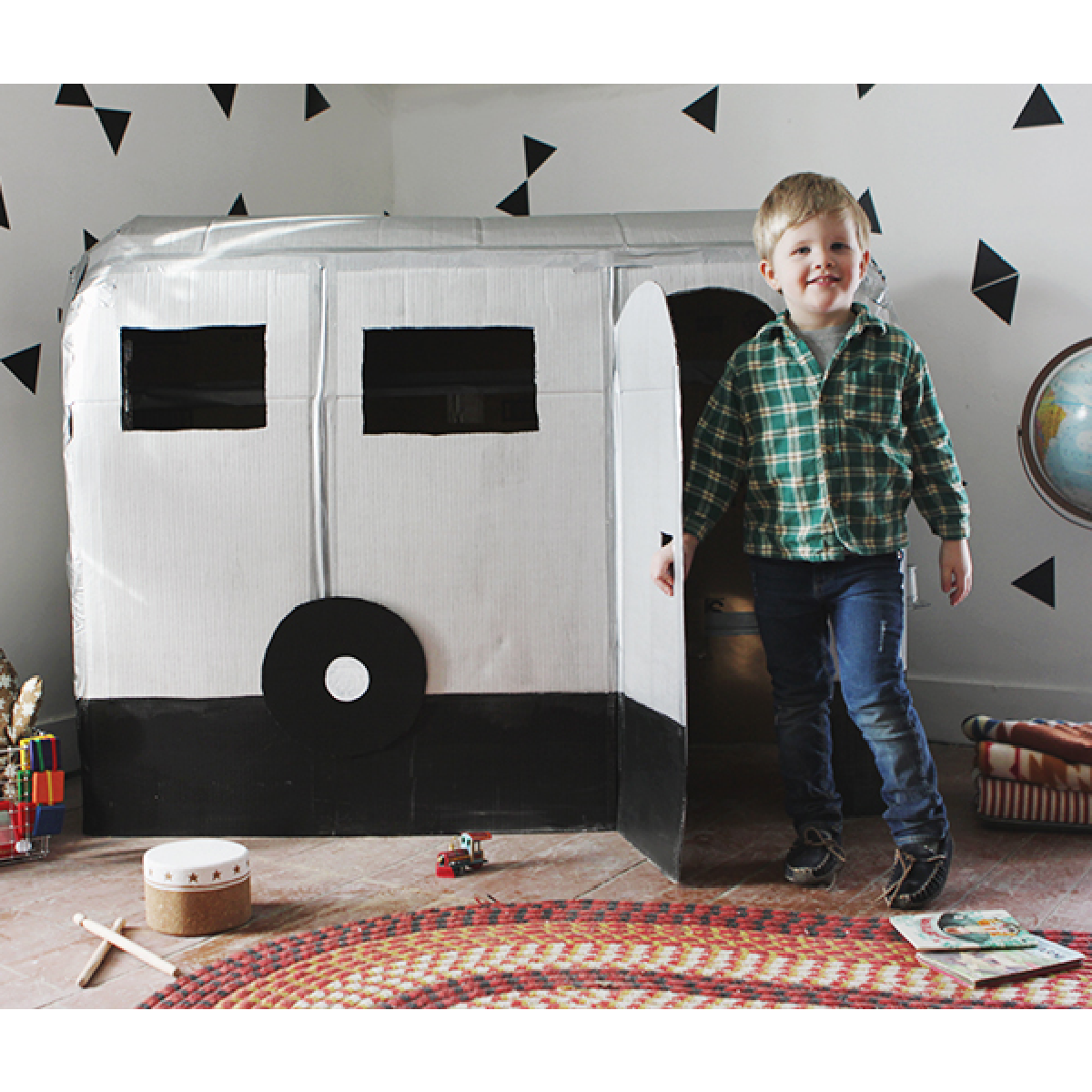 dress up ideas- gray and black cardboard camper with boy in green shirt- kids activities blog