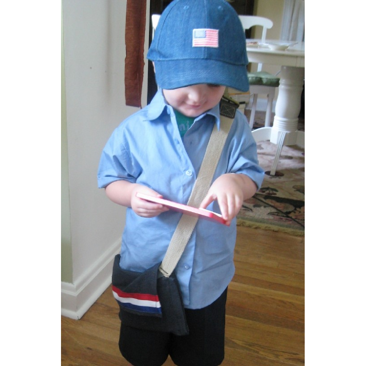 Dress up ideas- little boy in blue clothes with bag dressed like mail man- kids activities blog