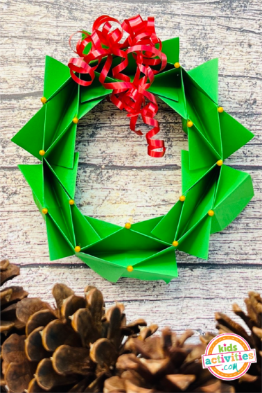 Image shows the final origami wreath product with christmas decorations.